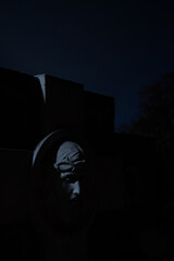 non-existent sculpture cemetery tomb view of marble face at night time with game of light and...