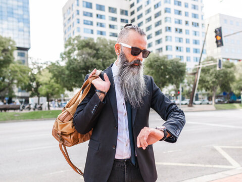 Stylish hipster checking time on wristwatch
