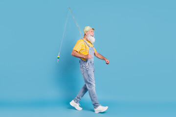 Profile side photo of aged man happy positive smile go walk fisherman spinning rod isolated over...
