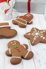 Traditional christmas gingerbread cookies over a wooden table with gift box