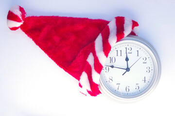 silver clock showing a quarter to 12 with Christmas Santa hat on