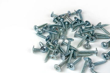 large pile of silver metal screws isolated on white background. close-up. copy space