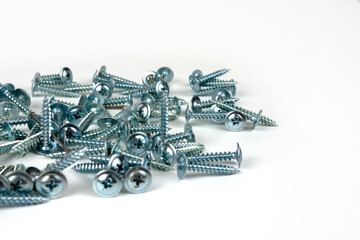large pile of silver metal screws isolated on white background. close-up. copy space