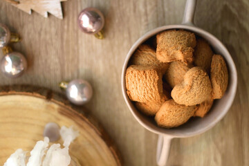 Bowl of cinnamon cookies, lit candles and various Christmas decorations on the table. Flat lay.