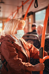 Woman wearing surgical protective mask in a public transport