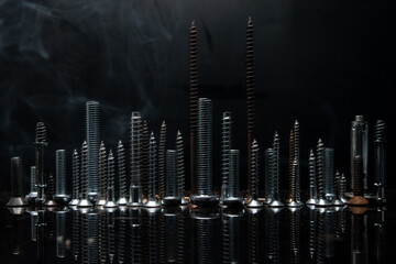Skyline with various screws and bolts on a reflective surface in the dark background