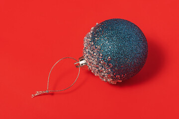 Christmas composition in blue and red colors. Blue Christmas toy on a red background.