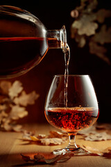 Cognac is poured into a glass from a bottle.