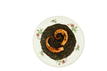 Octopus tentacles from the heart-shaped top view arranged on bed of mole negro with noodle...
