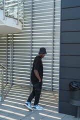 Chico negro atlético con ropa urbana posando en la calle