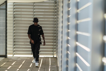 Chico negro atlético posando con ropa urbana en zona urbana