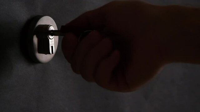 4K - In the dark, a hand inserts the key into the lock
