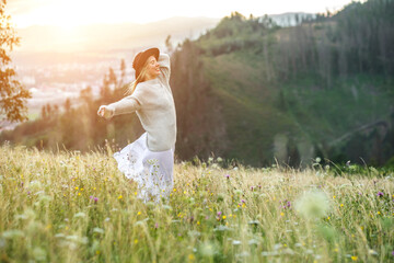 Fototapeta na wymiar Portrait happy woman enjoying sunset stay on the green grass on