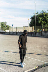 Chico negro atlético con ropa urbana posando en la calle