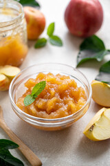 Homemade delicious fruit jam in glass bowl, made from red fresh apples.