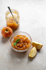 Homemade delicious fruit jam in glass bowl, made from red fresh apples.