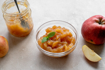 Homemade delicious fruit jam in glass bowl, made from red fresh apples.