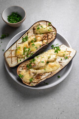 Vegetarian food. Baked aubergines stuffed with cheese, olive oil and herbs. Healthy food concept. Lifestyle food photo.