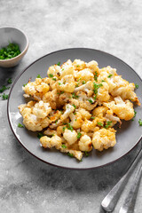 Vegetarian healthy food. Cauliflower baked with cheese, olive oil and parsley.