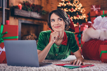 Fototapeta premium Photo of dreamy thoughtful young lady wear elf clothes browsing modern device writing letters smiling indoors house home room