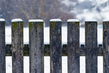 Winter background with a snow-covered wooden fence