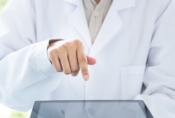 Doctor, standing, pointing at the tablet computer screen, close-up shot.