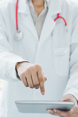 Doctor, standing, pointing at the tablet computer screen, vertically, close-up shot.