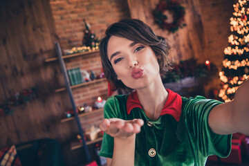 Fototapeta na wymiar Self-portrait of attractive cheerful girl elf sending you air kiss staying at home modern loft industrial interior indoors