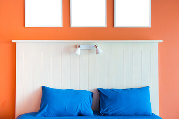 Modern and minimalist interior of bedroom. Blue bed with orange wall.