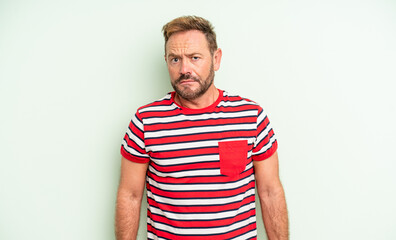middle age handsome man feeling sad and stressed, upset because of a bad surprise, with a negative,...