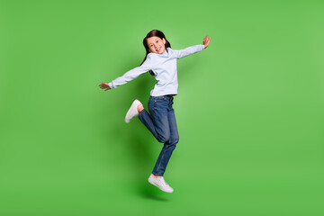 Photo of cute beautiful schoolgirl wear blue turtleneck jumping high arms sides smiling isolated...
