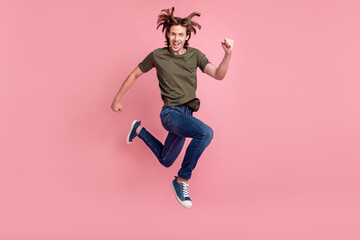 Full size profile side photo of young guy happy positive smile go walk run hurry jump isolated over pastel color background