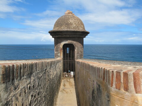 Bartizan or garita (Sentry Box) at Castillo San Felipe del Morro, San Juan, Puerto Rico. Stone walls, blue sky with clouds and deep blue sea. Rubbish at the floor. UNESCO World Heritage Site.