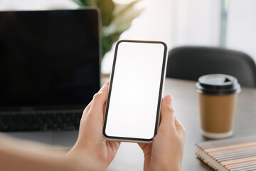 Close up of hand holding smartphone with white mock-up screen 