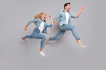 Profile photo of funny energetic couple jump run rush wear casual jeans outfit isolated grey color background
