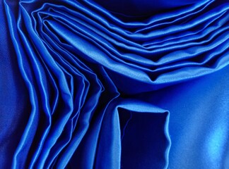 cloth folds. the edge of the blue satin fabric wrinkled irregular wavy