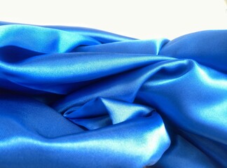 blue satin fabric. mound of wrinkled and crumpled blue satin fabric on a white background