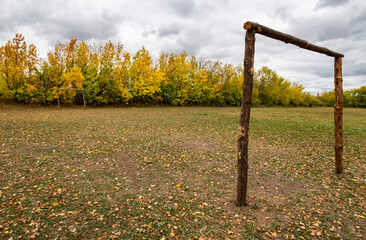 football goal made of logs on a deserted field in autumn