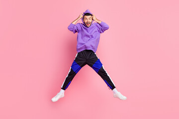 Fototapeta na wymiar Full size photo of funky millennial brunet guy jump wear hoodie pants shoes isolated on pink background