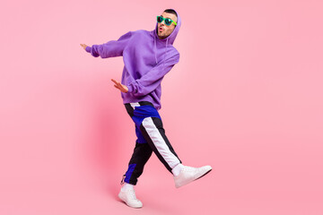 Full size photo of crazy millennial brunet guy dance wear eyewear hoodie pants shoes isolated on...