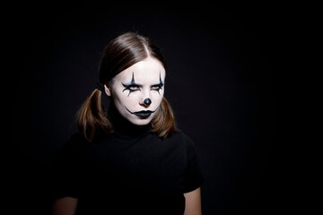 A creepy emotional portrait of a woman in a clown mask. Halloween.