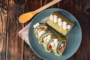 Chopped roll with spinach and red fish on plate.