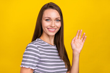 Photo of cheerful positive nice charming positive woman wave hand hello enjoy isolated on yellow color background