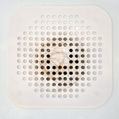 Hair on the silicone catcher grate when draining water in the bathtub