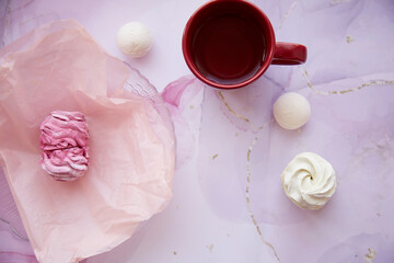 Natural delicate pink and white marshmallow and cup of tea with copy space. Top view. Winter aesthetic. Cozy winter weekends. Homemade sweets