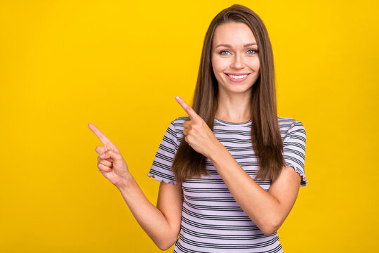 Photo of joyful happy cheerful young woman point funger empty space news comment sale isolated on yellow color background