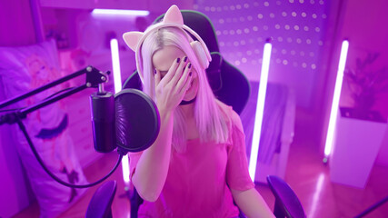 Amused cute gamer girl with cat ear headphones face palm while streaming © Video_StockOrg