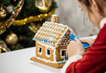 girl assembles a gingerbread house