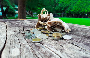 Coin gunnysacks with no sun light, one is down and one is up on wood plank with blur background