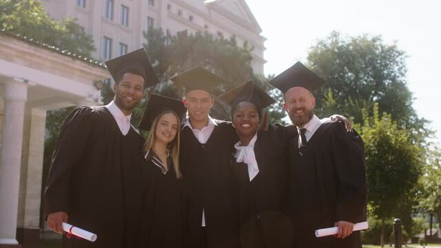 Modern college garden group of multiracial students graduates posing excited in front of the camera they take pictures for memories